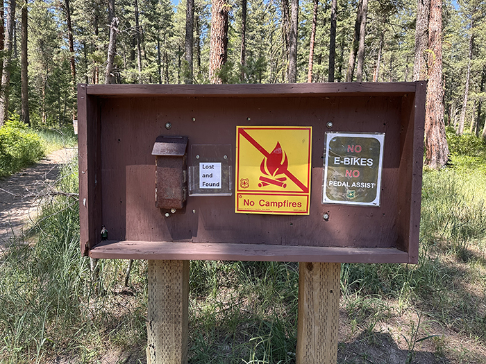 A picture of a trailhead sign forbidding e-bikes.