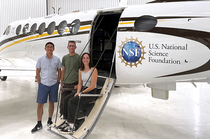 Lu Hu (left to right), Wade Permar and Amity Deters – pose with the plane used for their work.