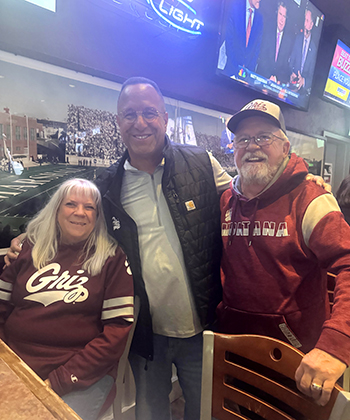 A picture of Brad and Carol Holm with UM head football coach Bobby Kennedy. 