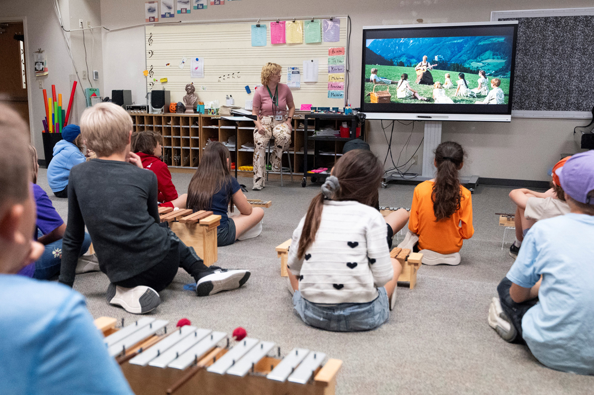 An image of Emma McMillan with students in the classroom. 