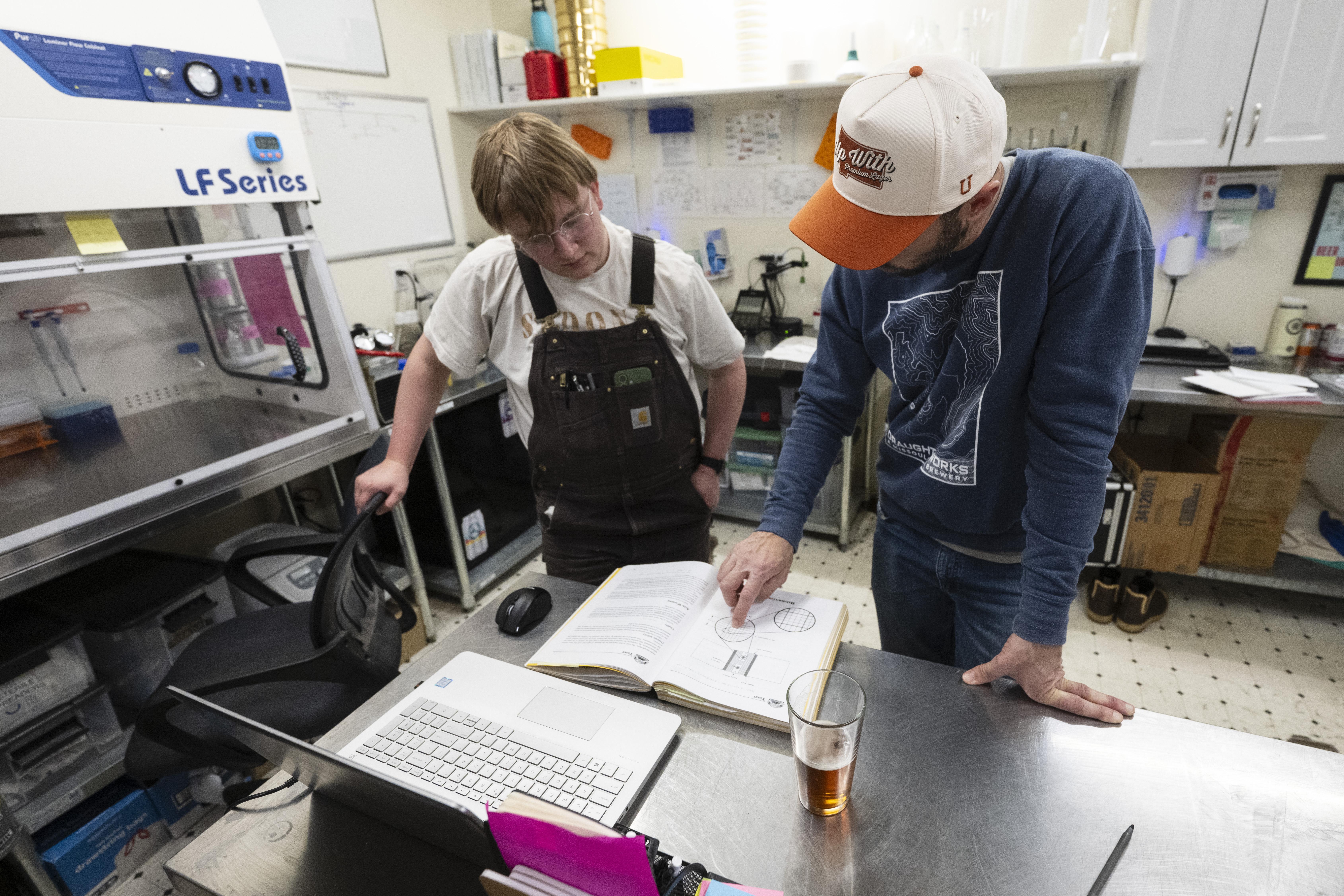 UM students look at paperwork in a lab.