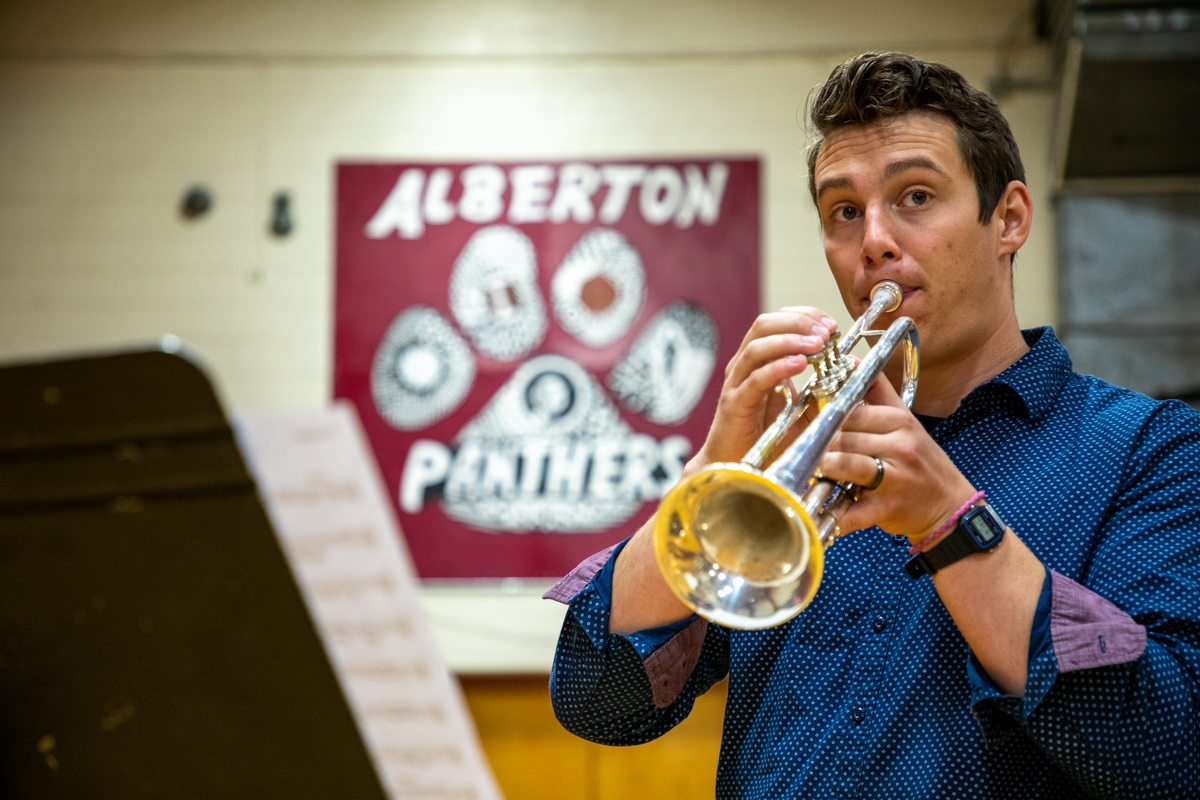A trumpet player plays in an elementary school gym 