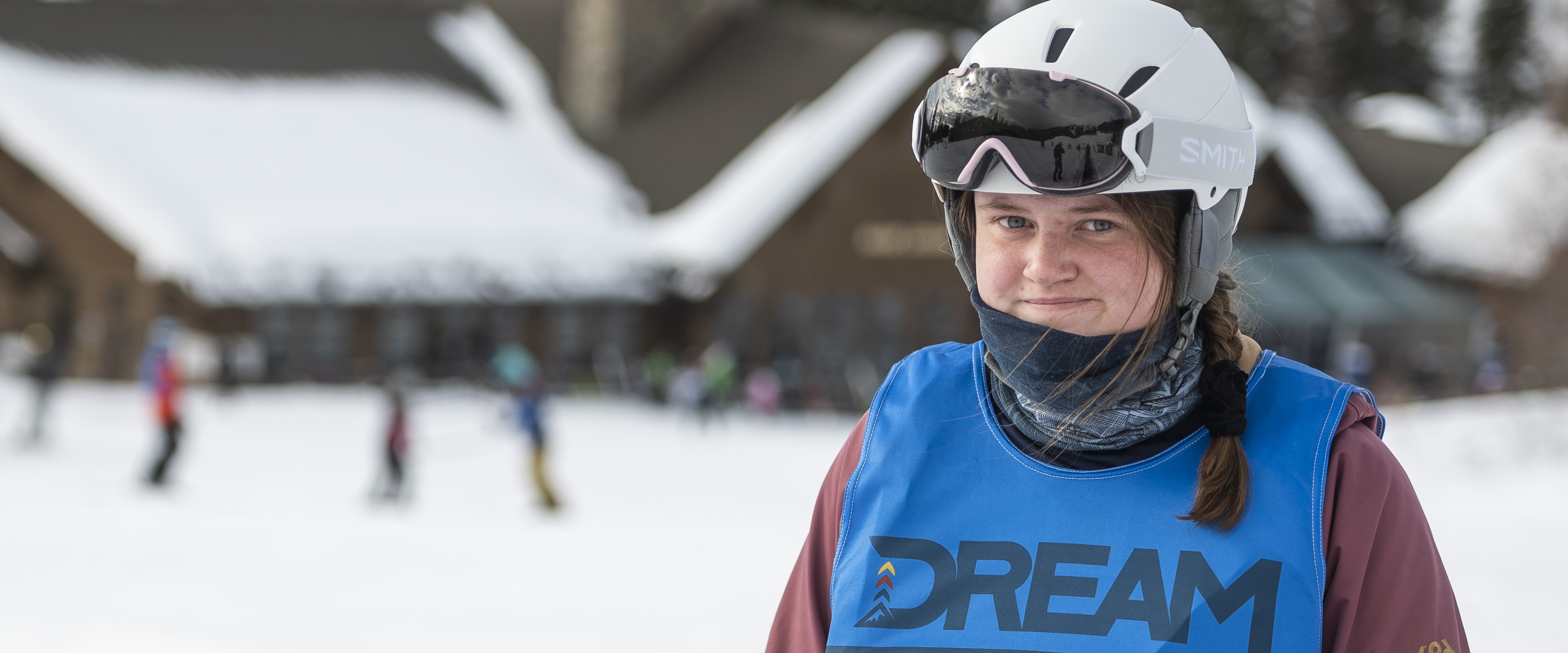 A woman in a ski helmet and a blue vest 