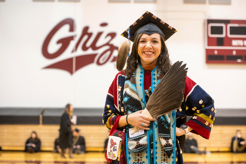 UM Graduate poses with indigenous regalia