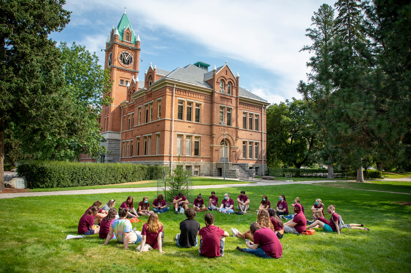 Students sit in circle outside of main hall at orientation 2019