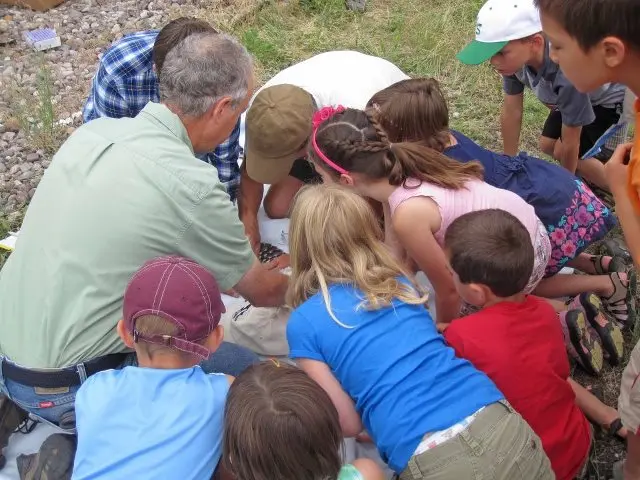 group of young kids around osprey research Erick looking at an unseen osprey chick