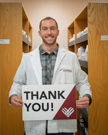 Pharmacy student holding a "Thank You" sign