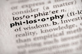 close up view of the word philosophy in a dictionary with surronding words and letters blurred