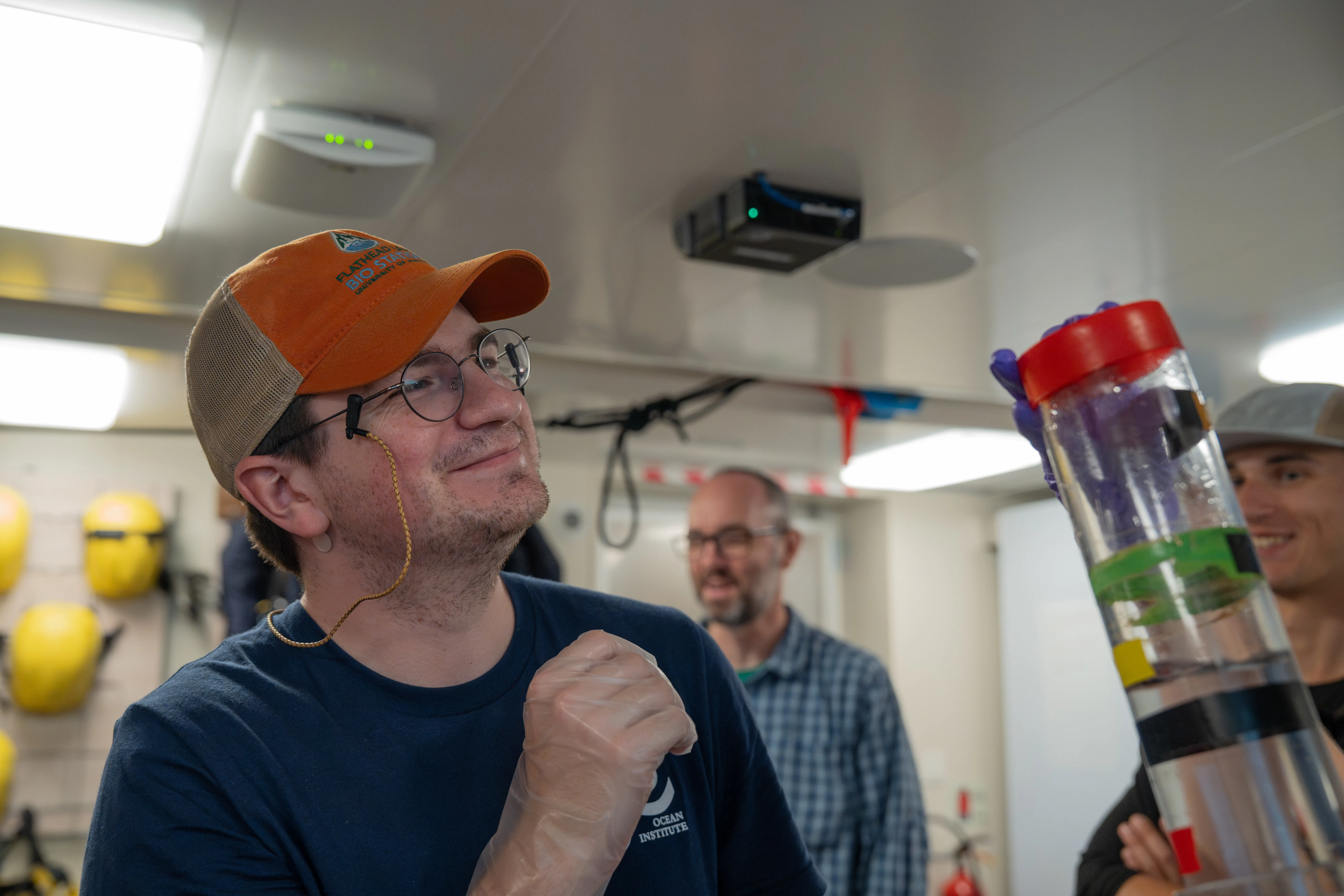 Jared McGourty, Systems Ecology Graduate Student, University of Montana looks at the sediment trap to analyze the flux of particles through the subsurface in the hydro lab aboard R/ V Falkor (too). CREDIT: Bernarda Cornejo Pinto / Schmidt Ocean Institute
