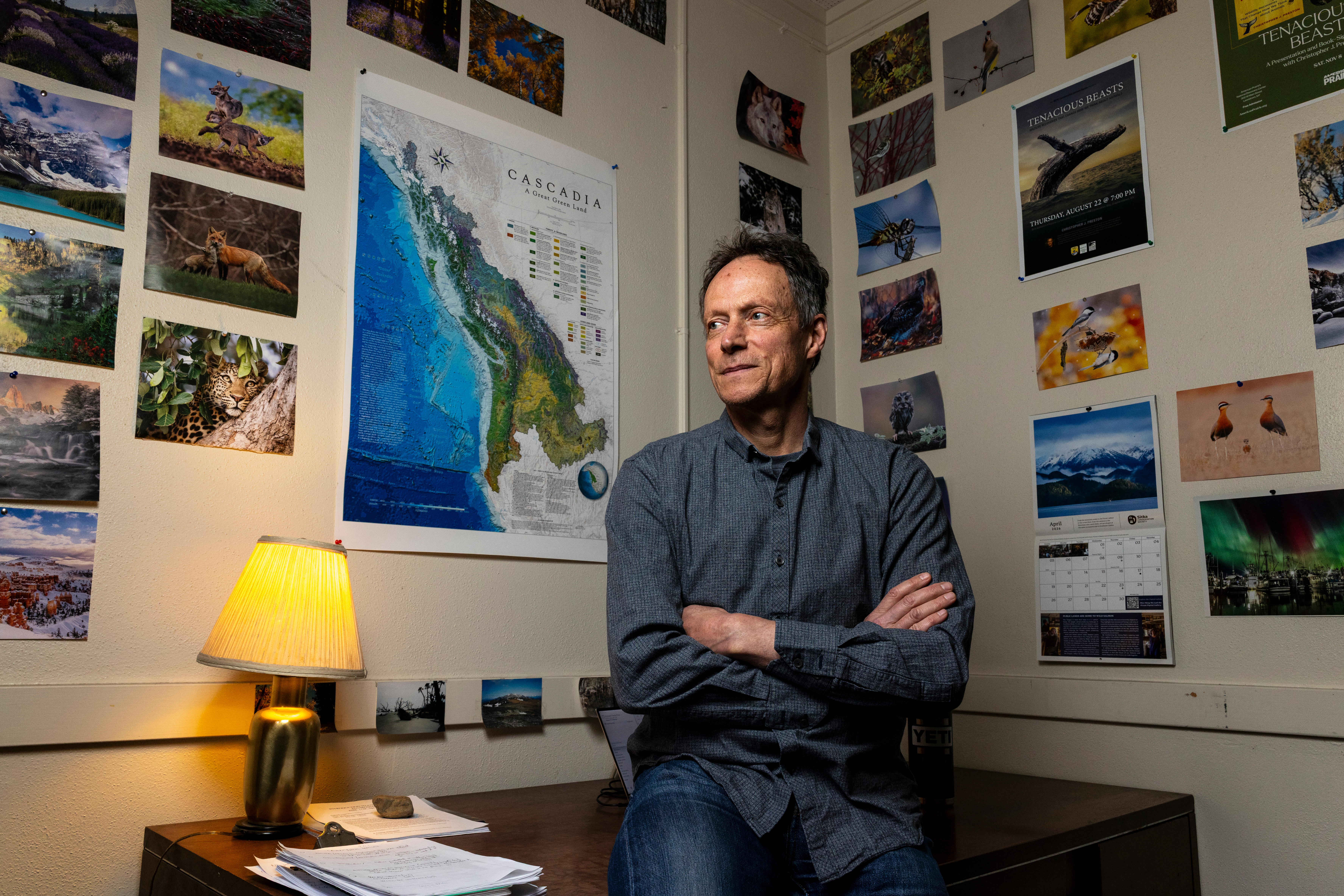Christopher Preston sitting in his office surrounded by photographs and posters
