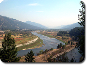 a bend in the clark fork river mountains in the background