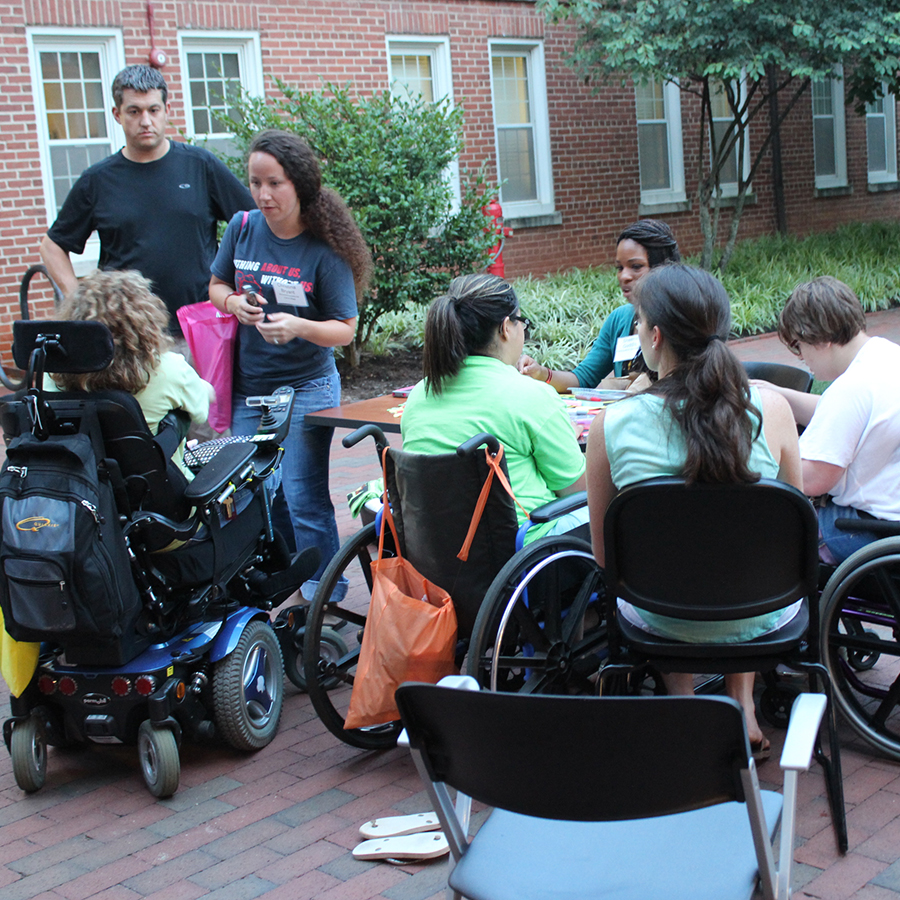 group of people, many using wheelchairs, outside