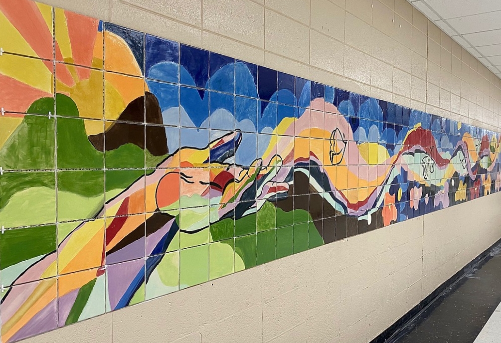 Photo of colorful painted tiles. A hand reaches out with waves and butterflies flowing from it. 