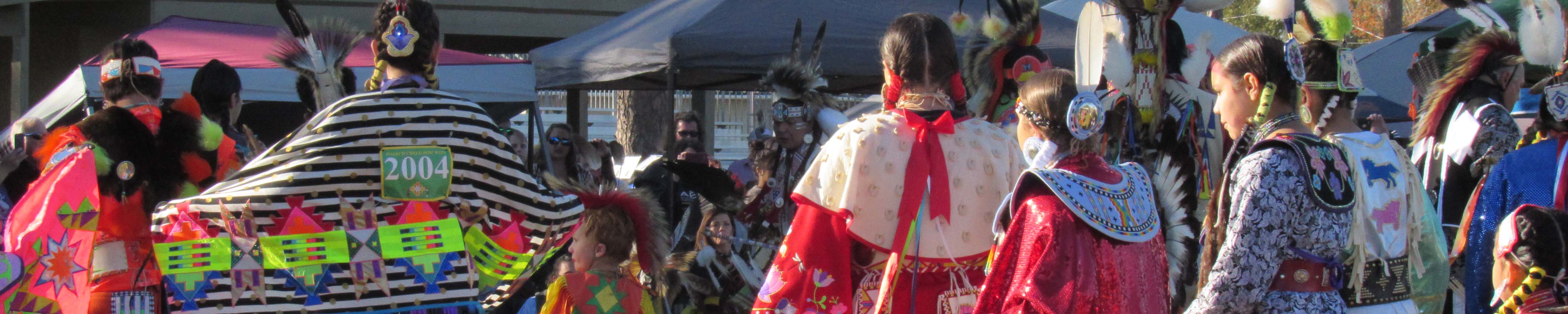 People in regalia performing a dance at a powwow