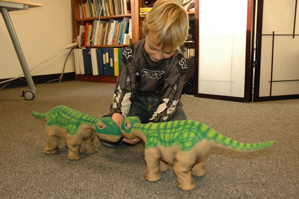 boy with 2 dinosaur robots