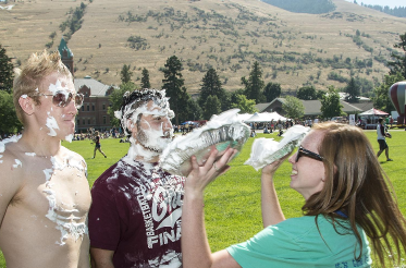 girl throwing pies in the face of two guys