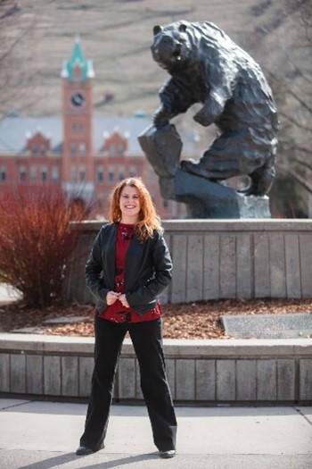 Dr. Jennifer Schoffer Closson stands in front of the University of Montana's grizzly statue.