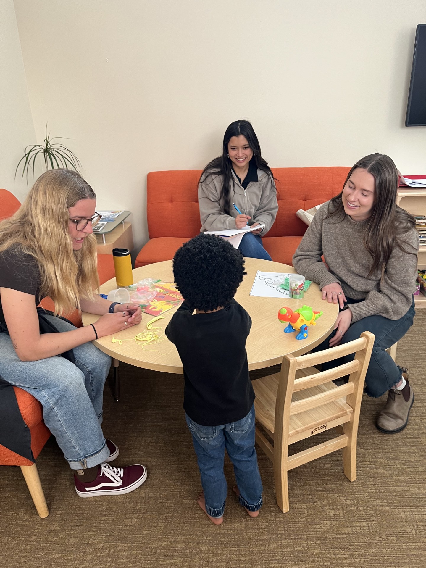 An image of three University of Montana occupational therapy doctorate students administering a pediatric assessment to a pediatric client. 