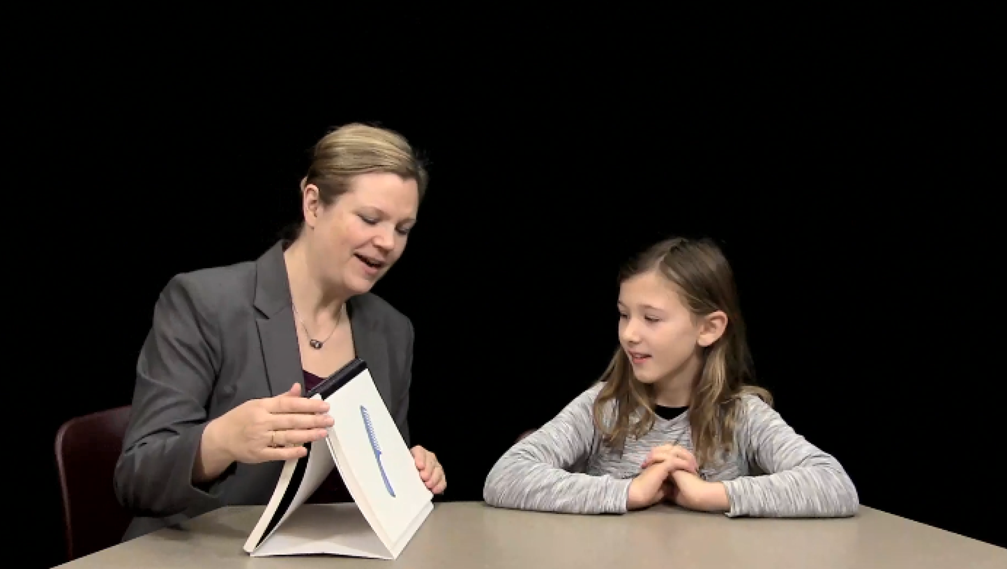 Dr. Glaspey works on speech sounds with a young child. The word in practice is comb.