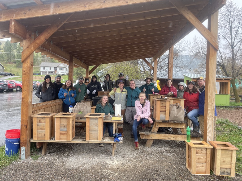 students at a garden taking cover while it rains