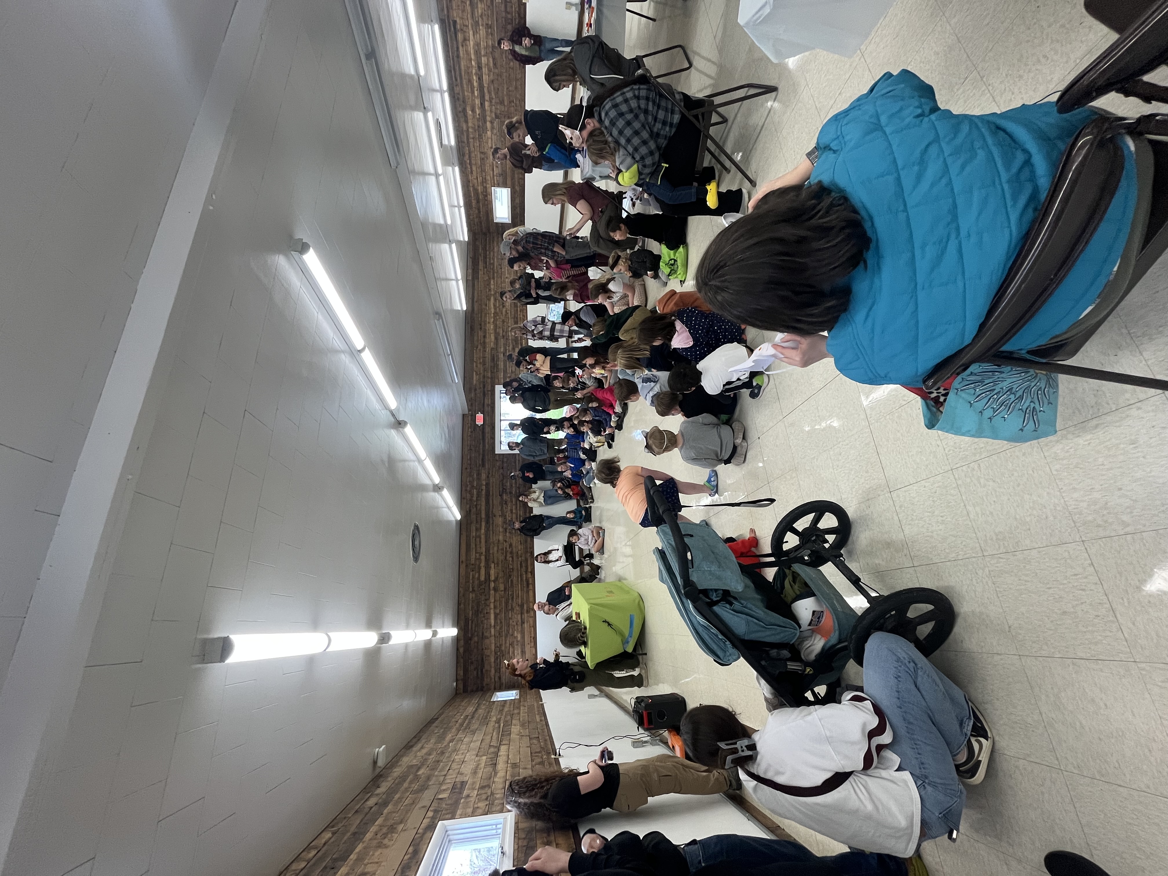 A crowd watches Jessi present Roana, a raccoon. 
