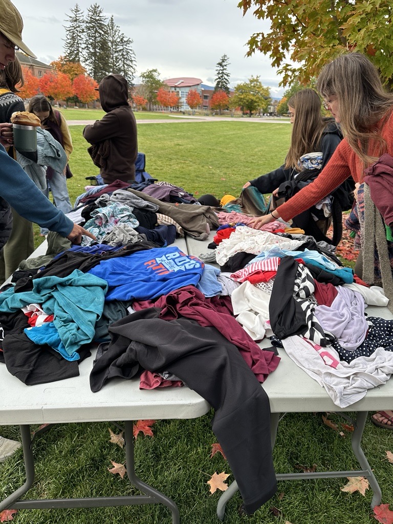 piles of clothes stack up on two tables on the oval