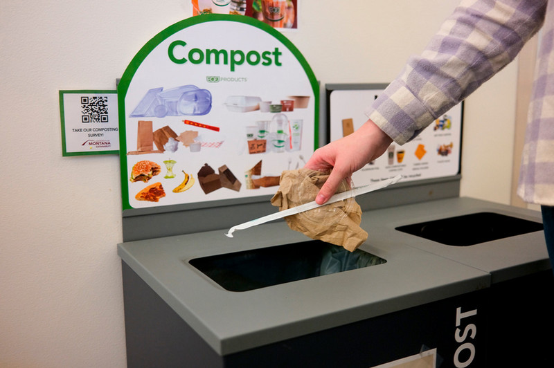 someone throwing compost into the compost bin in Gallagher