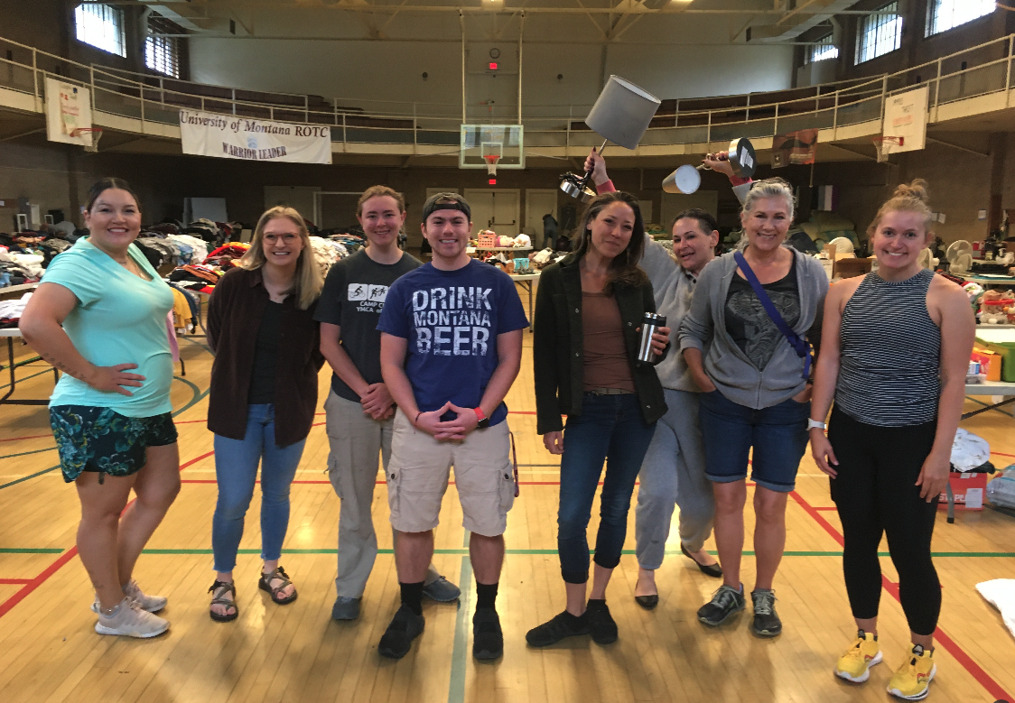 volunteers stand smiling in a line in schreiber gym