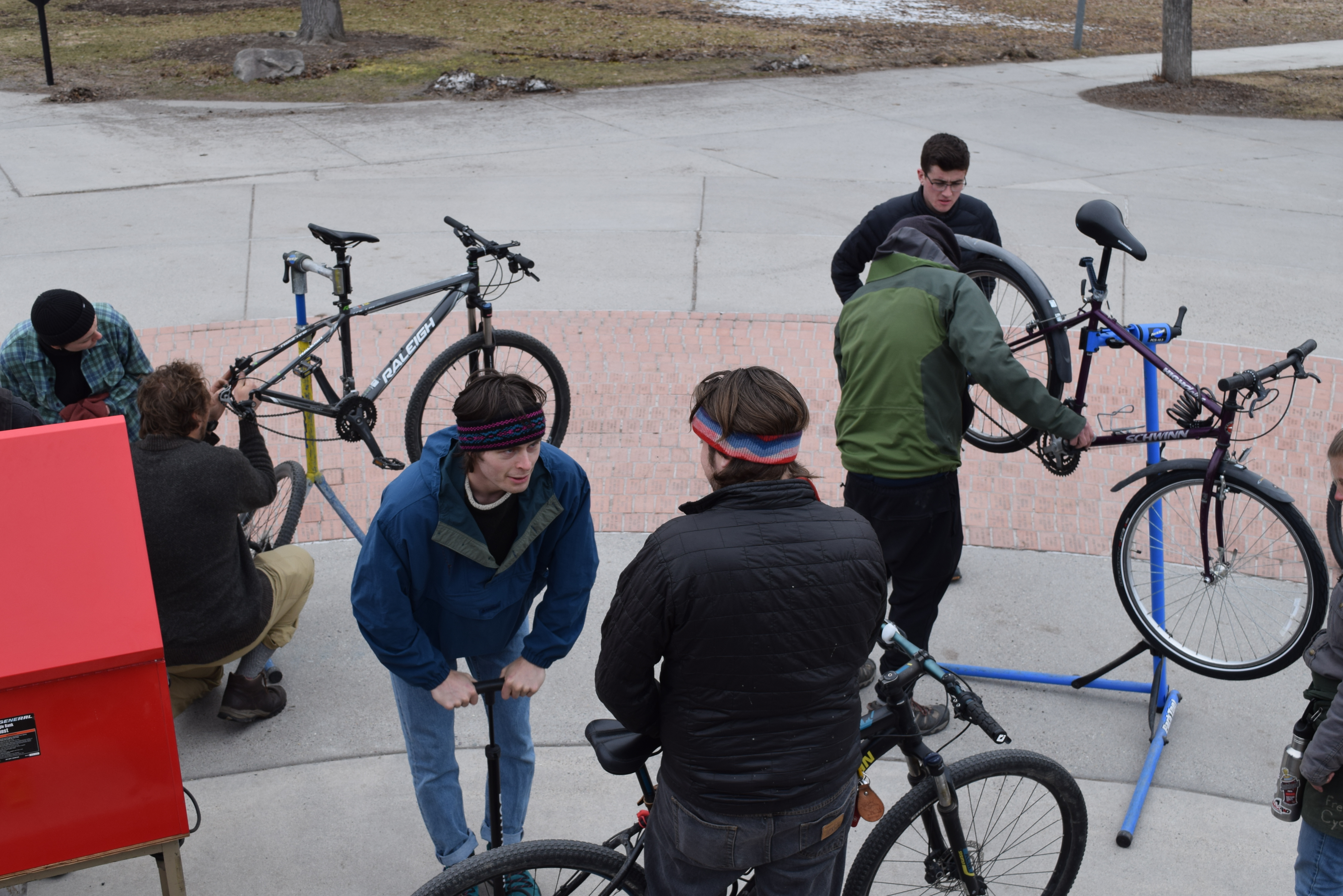 bike mechanics works on bikes on stand with owners standing around