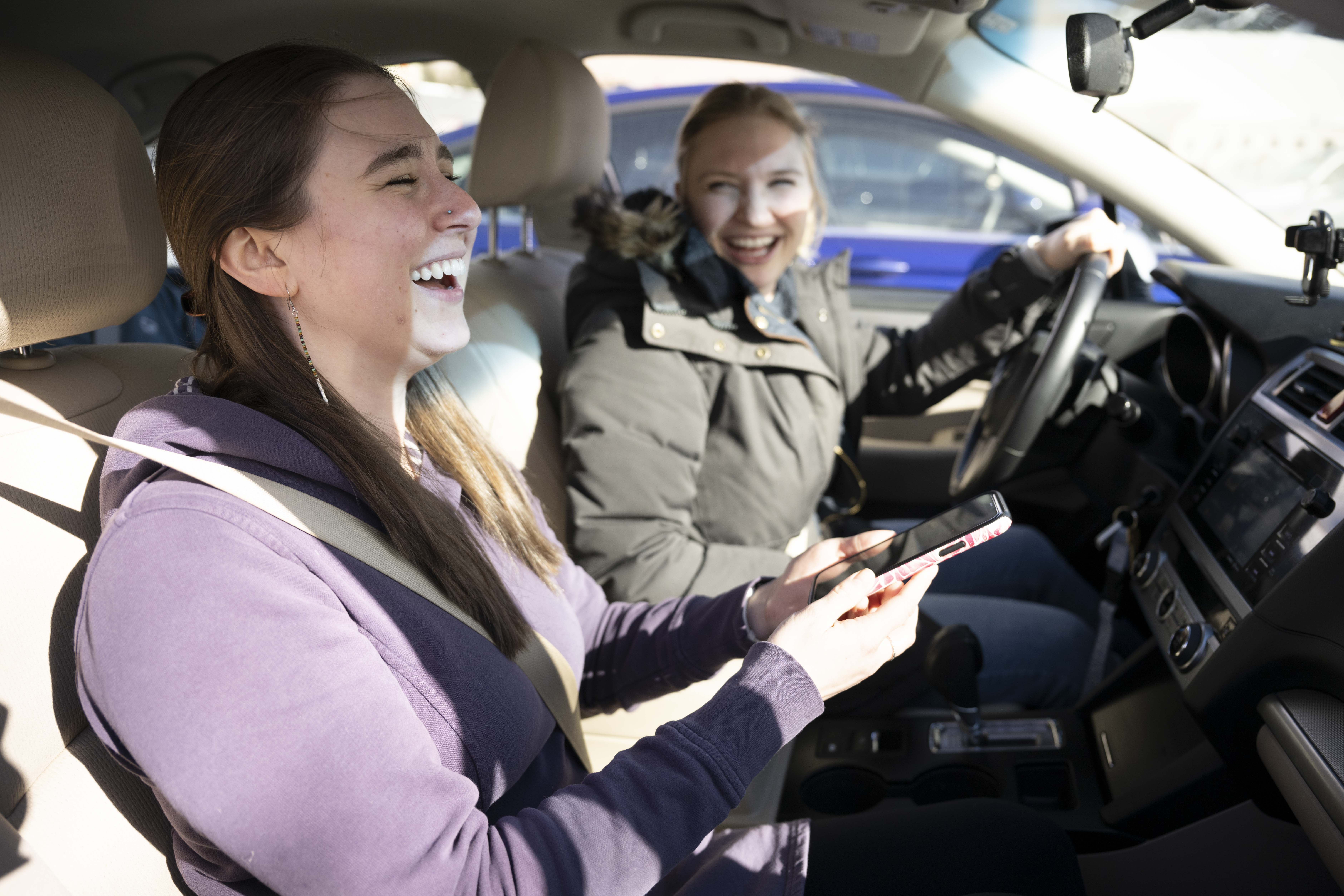 two girls smiling in the car