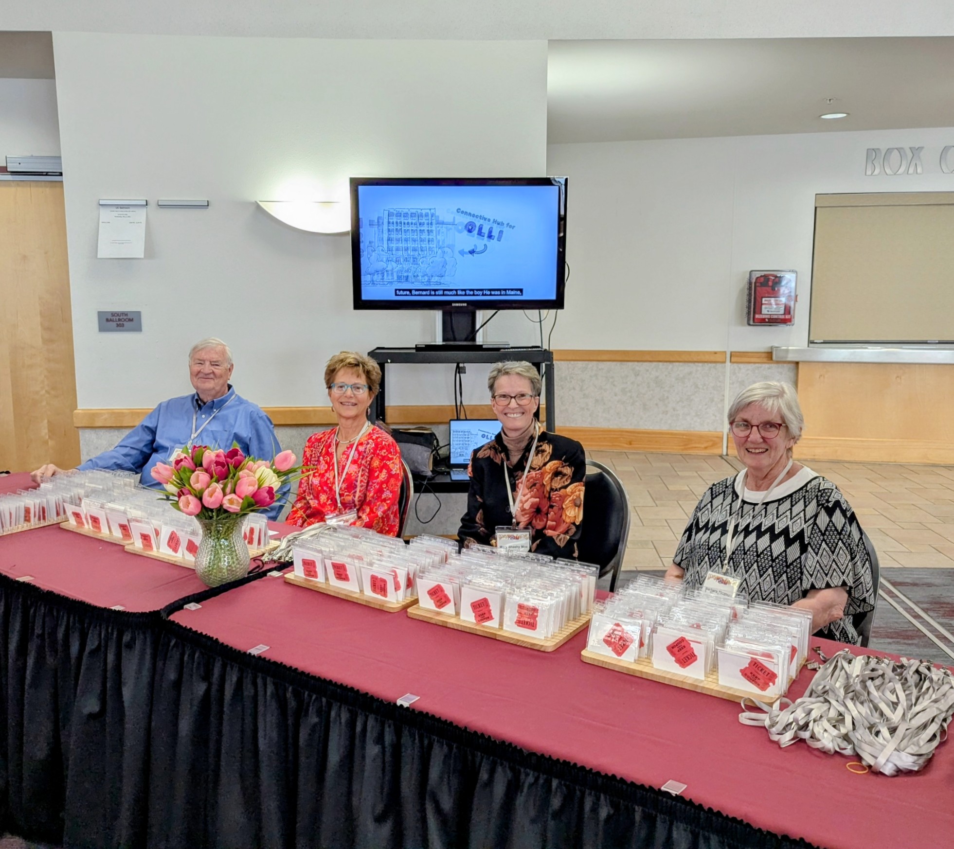 4 molli volunteers sitting at check-in table