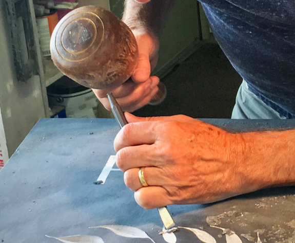 A hammer and chisel on stone.