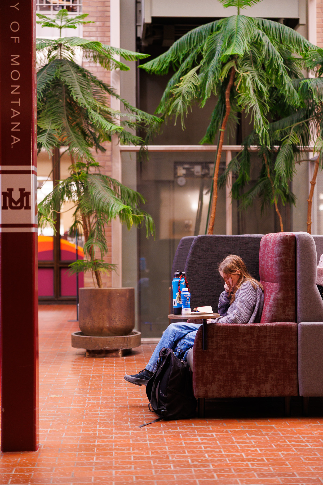 Girl reading a book in the UC Atrium 