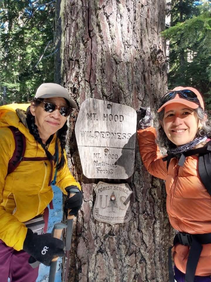 women with forest service sign